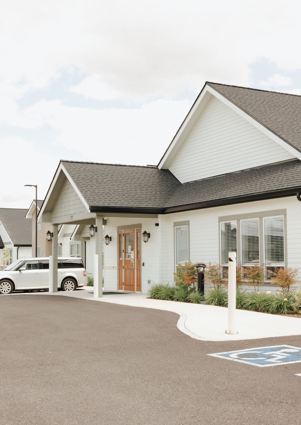 A suburban building with a parked car in front.