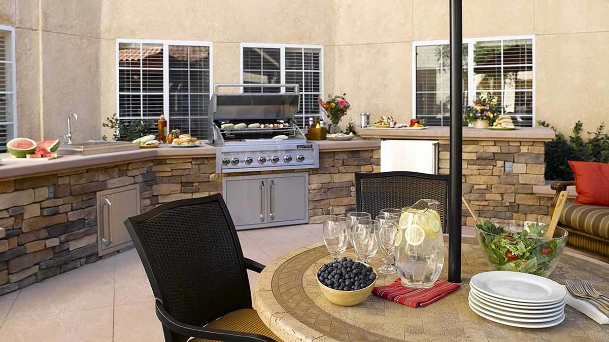 A cozy outdoor patio with a barbecue grill and seating area.