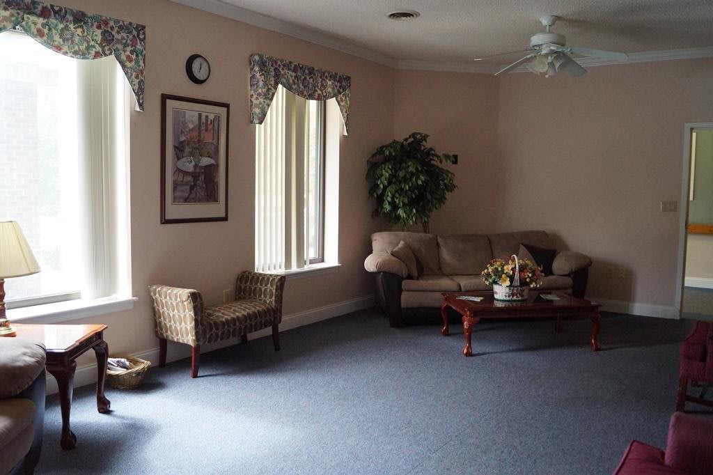 A cozy living room with a sofa, coffee table, and indoor plants.