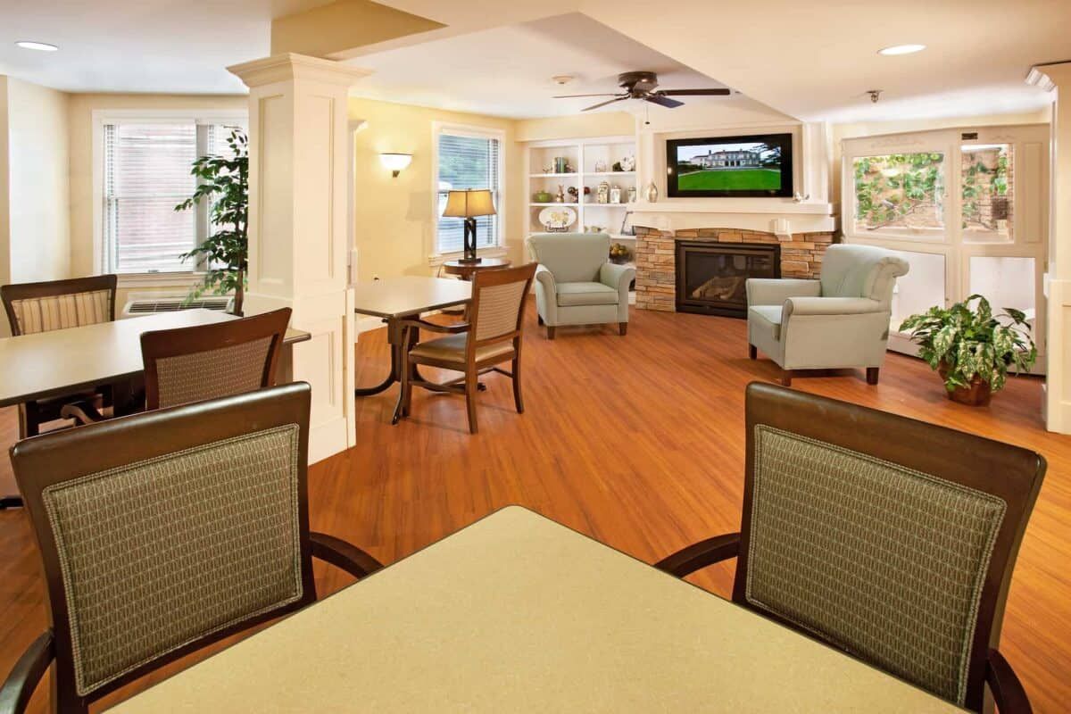 A cozy living room with a fireplace, seating area, and hardwood floors.