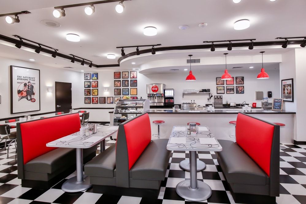 A retro-style diner with red booths and checkered flooring.
