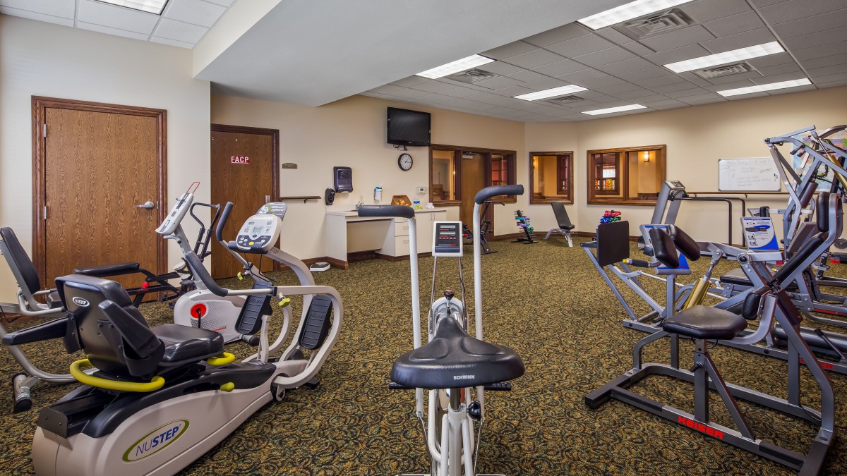 A spacious gym with various exercise equipment including stationary bikes.