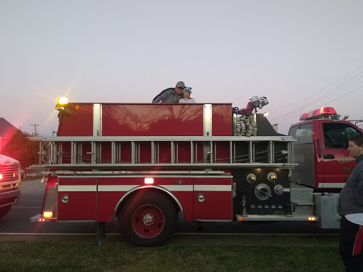 A fire truck stationed with a firefighter preparing for action.