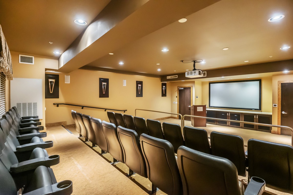 A cozy indoor theater with rows of seating facing a projection screen.