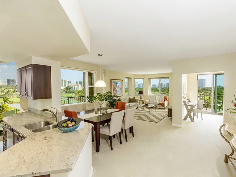 A bright and modern open floor plan featuring a kitchen, dining area, and living room.