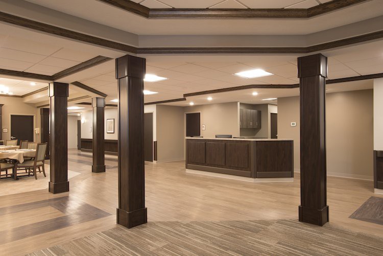 A modern reception area featuring dark columns and wooden flooring.