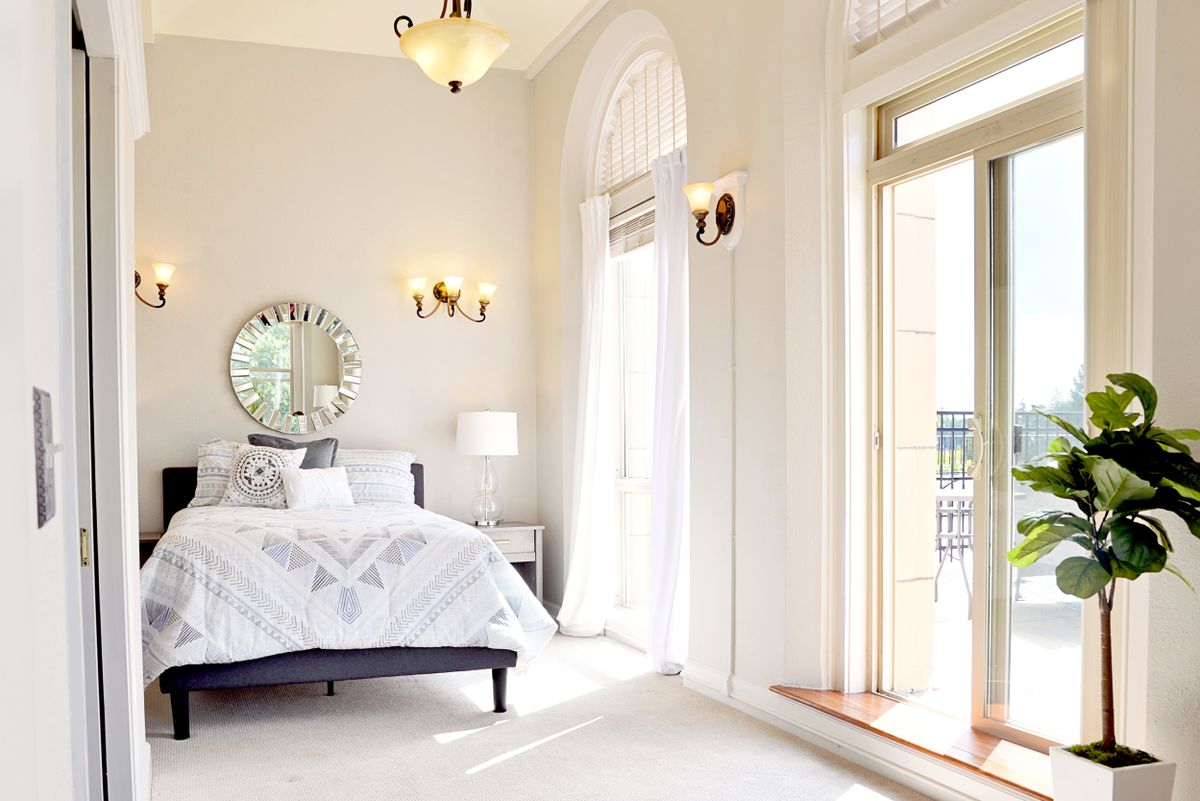 A bright and airy bedroom with large windows and modern decor.