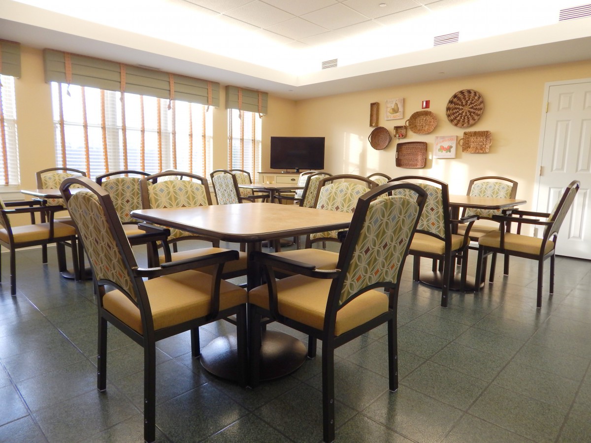 A well-lit dining room with multiple tables and chairs, decorated with wall baskets.