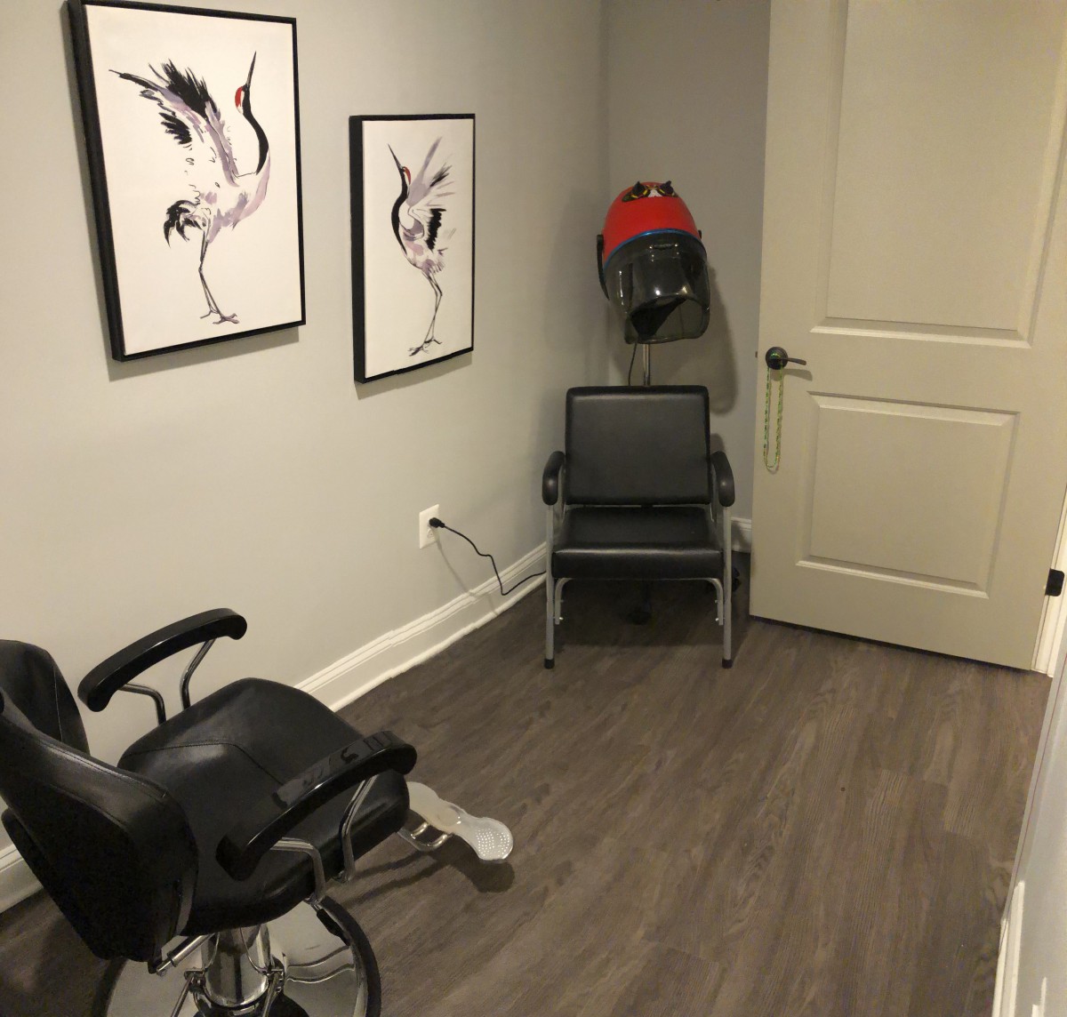 A minimalist barbershop interior with chairs and modern wall art.