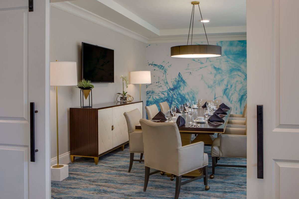 A modern dining room with elegant furnishings and abstract wall art.