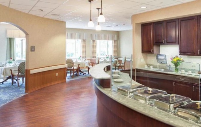 A modern dining area with a curved serving counter and seating by the windows.