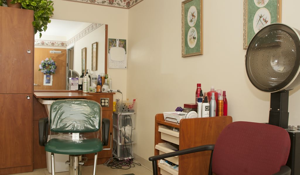 Interior of a hair salon with a chair, mirror, and hair products on display.