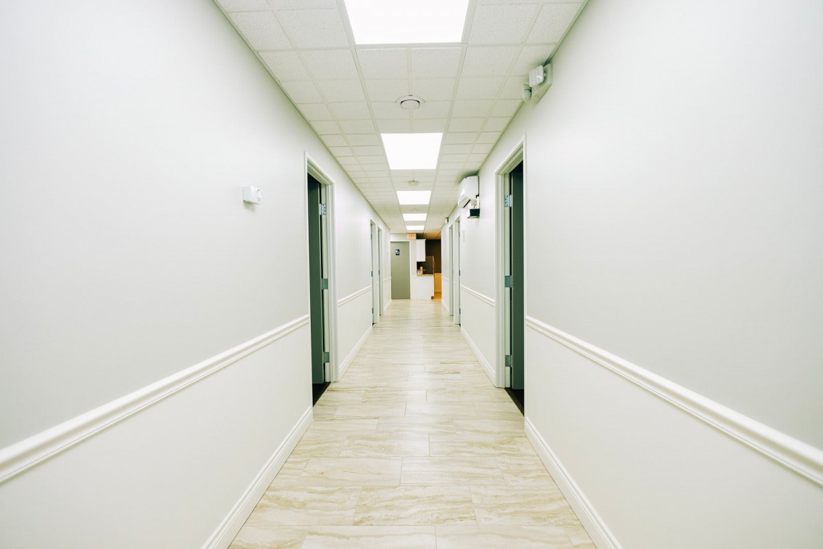 A long, well-lit hallway with multiple doors on either side.