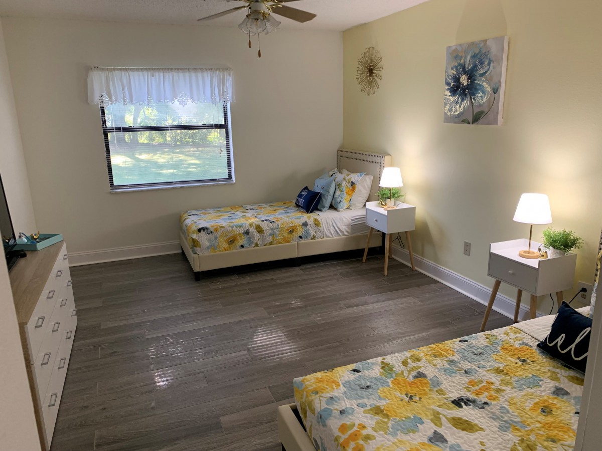 A cozy bedroom with two single beds, bright decor, and natural light.