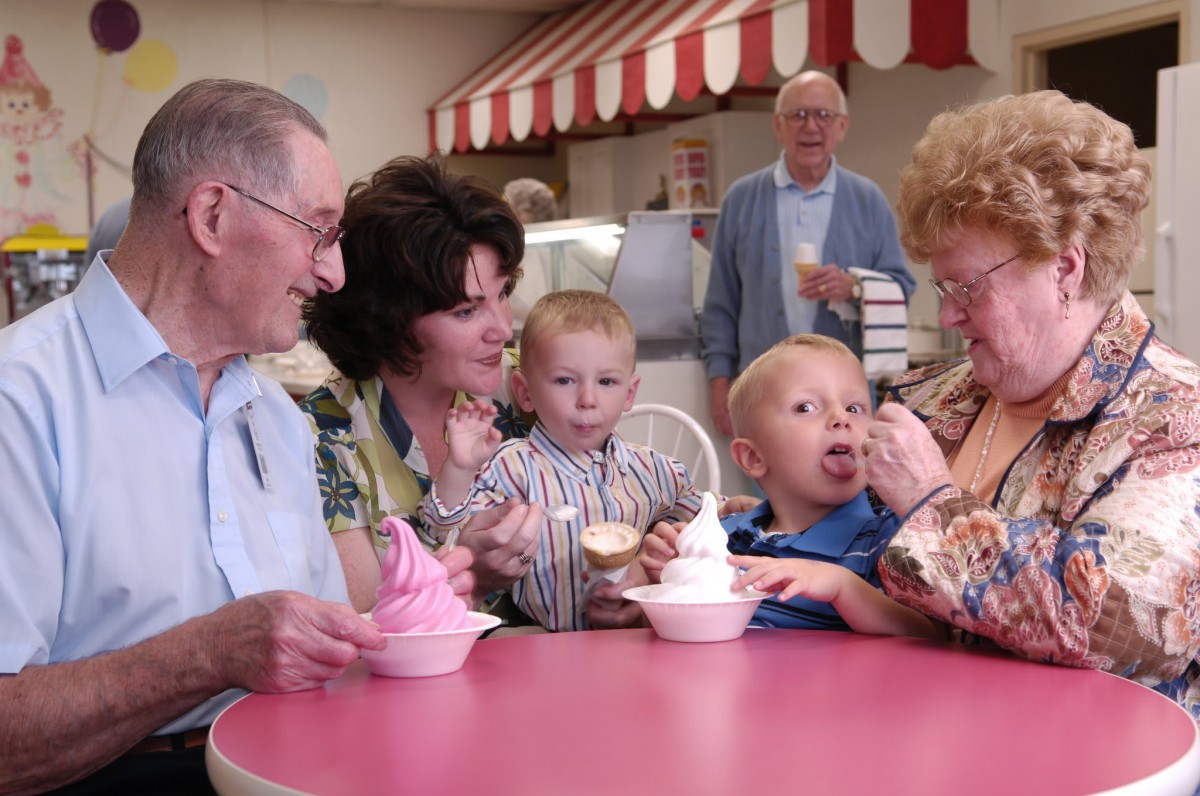 A family enjoying ice cream together at a table indoors.