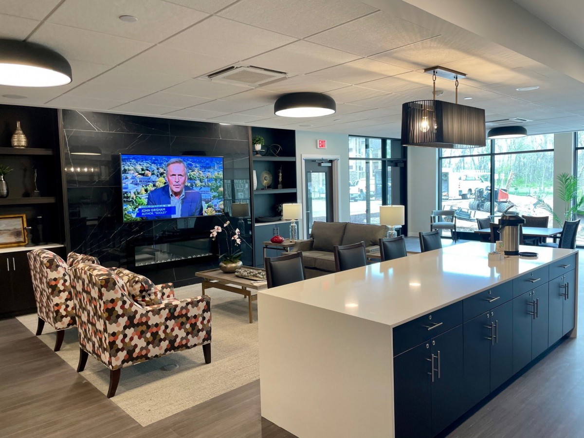 A modern lounge area featuring comfortable seating, a television, and contemporary lighting.