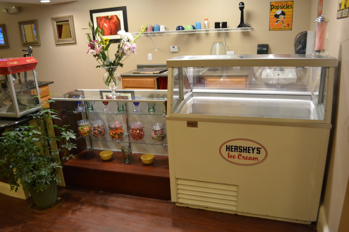 An interior view of an ice cream shop with a scooping station and decorative elements.