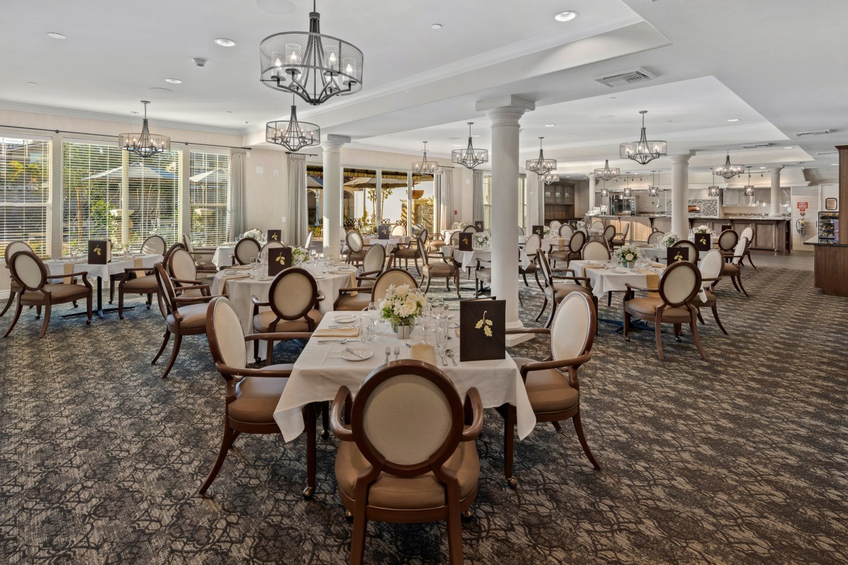 An elegant dining room with beautifully set tables and classic chandeliers.