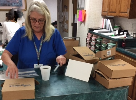 A woman organizing packages at her office desk.