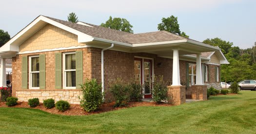 A suburban brick house with a well-maintained yard and landscaping.