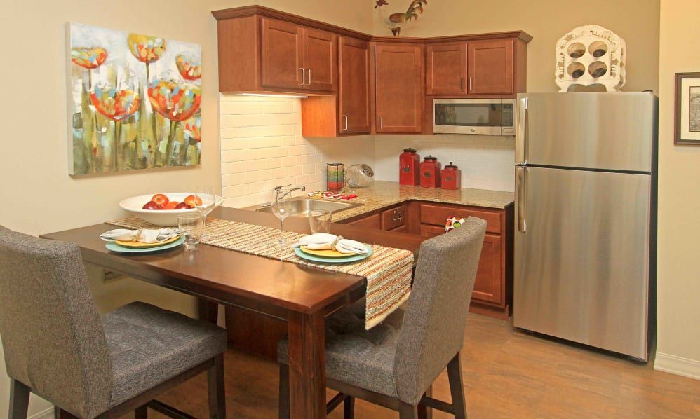 A cozy kitchen and dining area with wood cabinets and modern appliances.