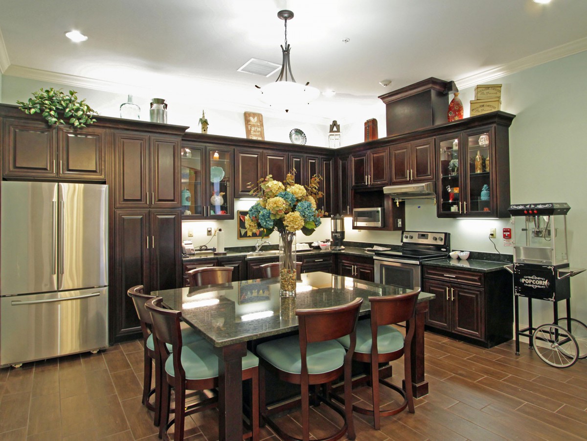 A modern kitchen with dark wood cabinets and a central island featuring a dining area.