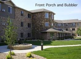 A stone-exterior building with a front porch and well-maintained landscaping.