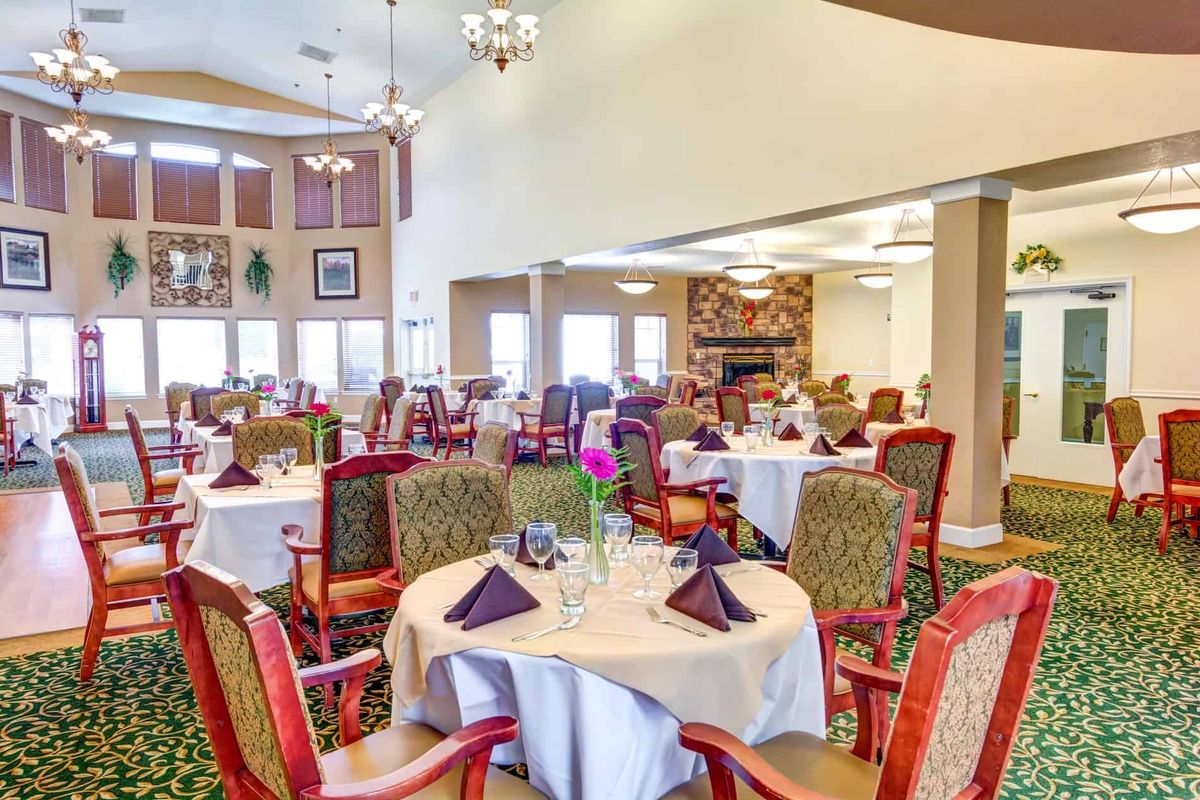 Elegant dining room with neatly arranged tables and chairs, featuring a warm and inviting atmosphere.