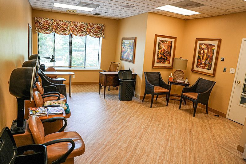 A cozy waiting room with chairs and art on the walls.
