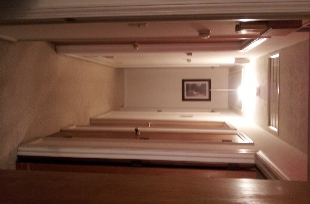 A well-lit hallway with multiple doors and a picture frame on the wall.