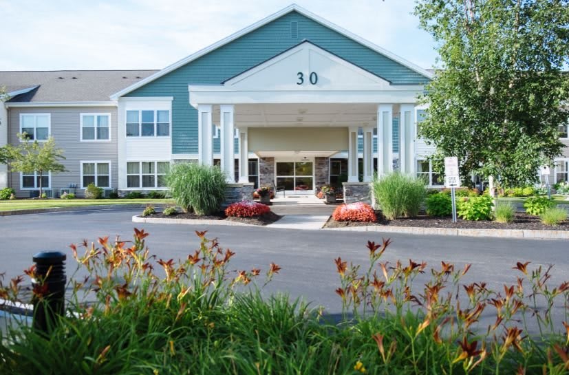 Front view of a large building with a landscaped entrance.