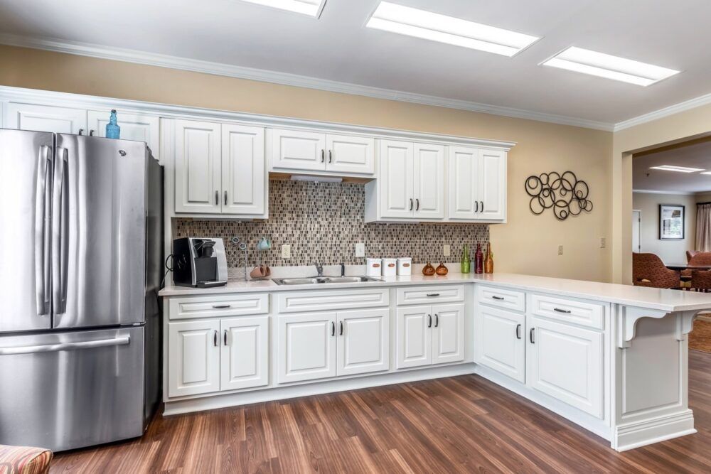 Modern kitchen with white cabinets and stainless steel appliances.