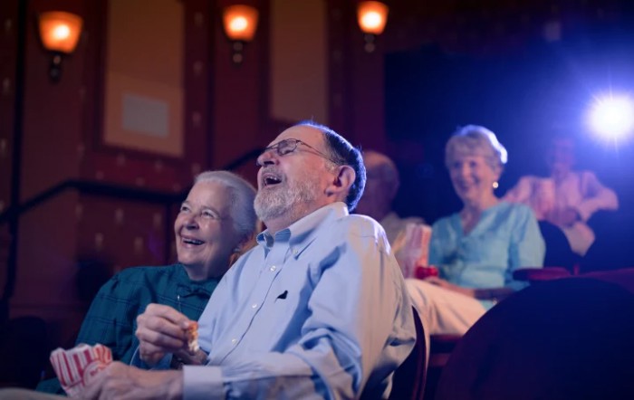 Elderly audience enjoying a performance in a theater.