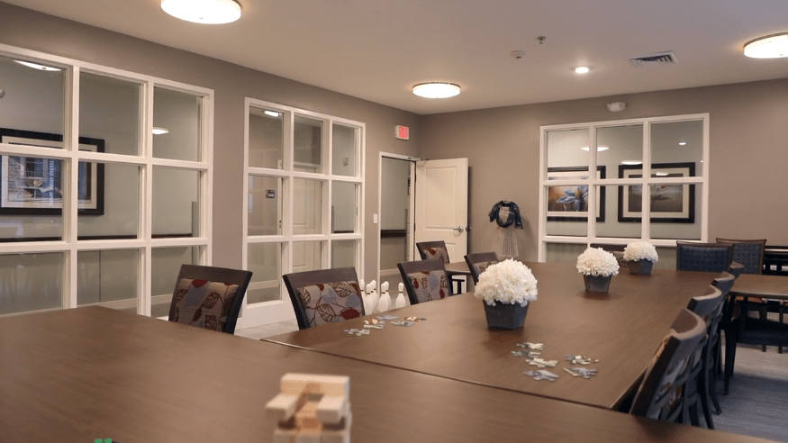 A well-organized meeting room with a conference table, decorated with flowers and a jenga game piece.