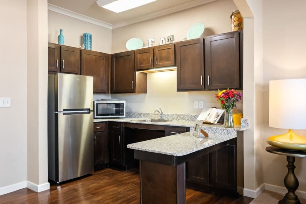A modern kitchen with dark wood cabinets, stainless steel appliances, and a bright countertop.