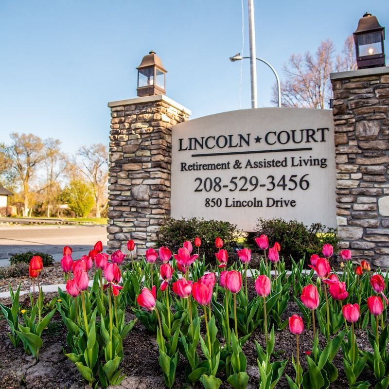 Lincoln Court Retirement & Assisted Living sign surrounded by blooming tulips.