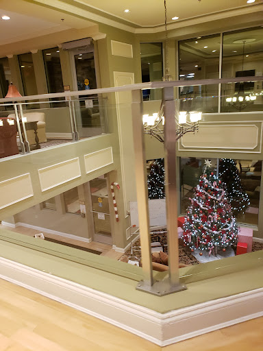 A beautifully decorated Christmas tree in a modern shopping mall, showcasing vibrant holiday lights and a festive atmosphere.
