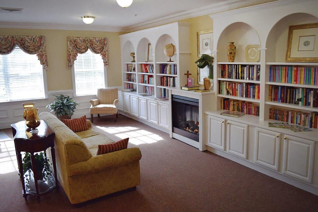 A cozy living room with built-in bookshelves, a fireplace, and comfortable seating.