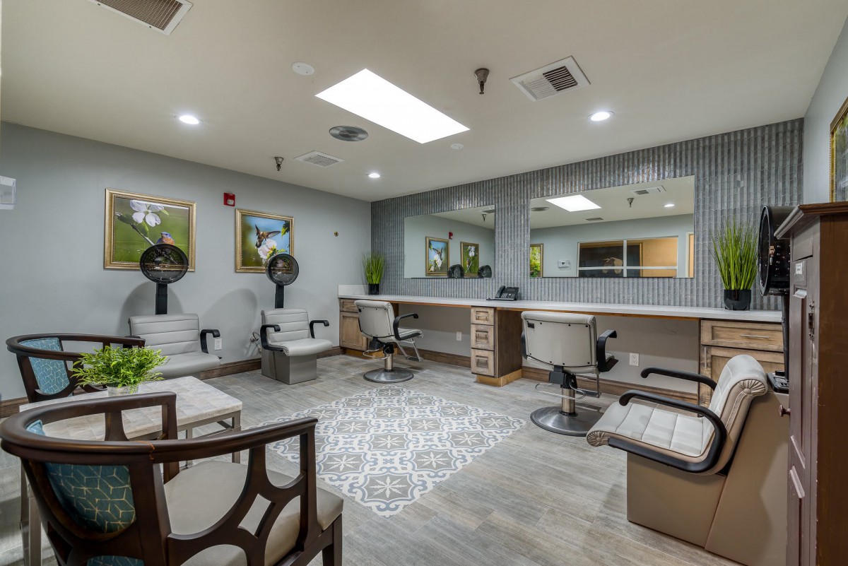 A modern and well-equipped hair salon interior with styling chairs, mirrors, and hairdryers.