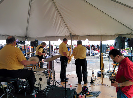 A live band performing under a tent at an outdoor event.