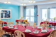 A brightly colored dining room with tables set for guests.