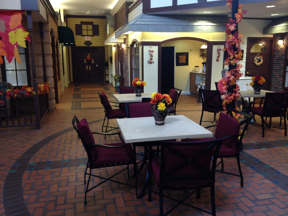 A cozy indoor restaurant setting with decorated tables and chairs, illuminated by warm lighting.