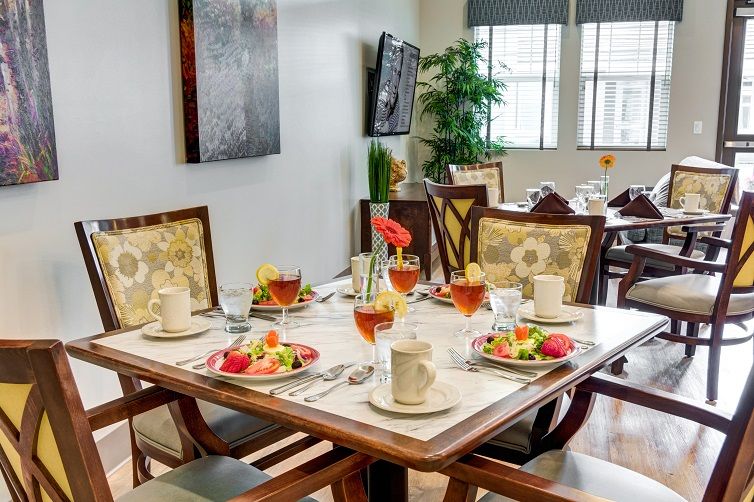 An elegantly set dining table with salads and drinks in a well-appointed restaurant.