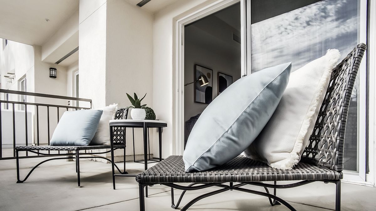 A modern outdoor patio with comfortable cushions and stylish furniture.