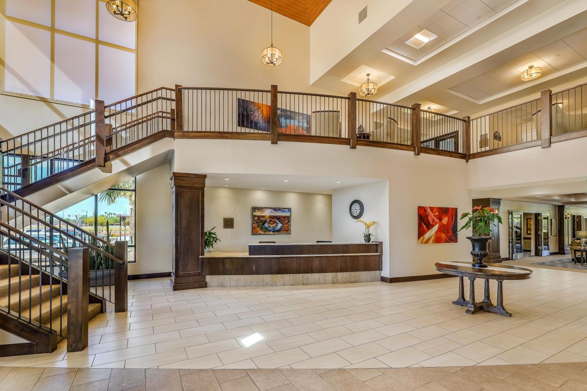 A spacious and modern lobby with a reception desk and balcony.