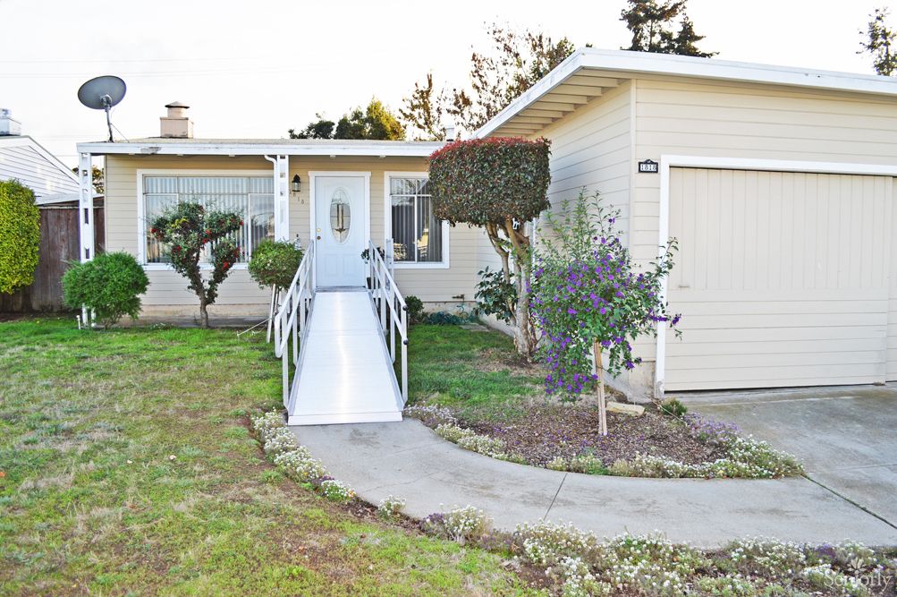 A single-story house with a wheelchair-accessible ramp leading to the front door.