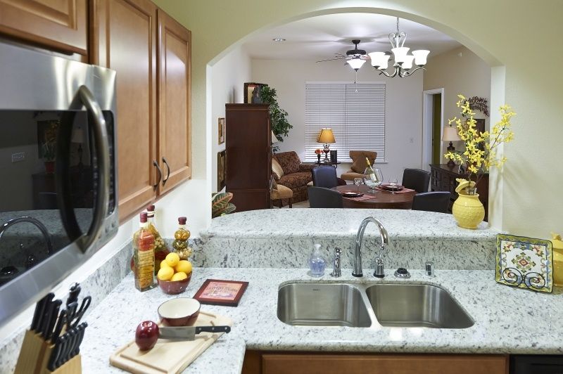 A view from the kitchen featuring a granite countertop with a sink, overlooking the living room area.