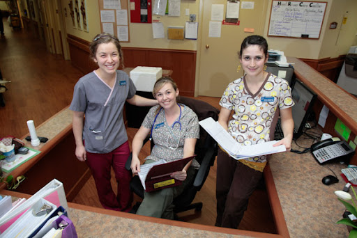 A friendly team of healthcare professionals poses together in a medical office.