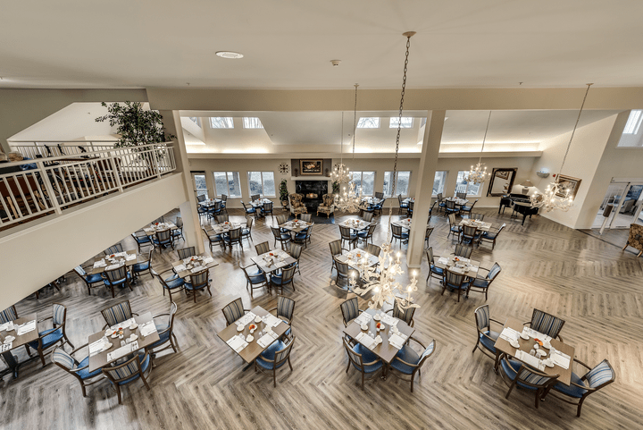 A spacious and modern restaurant dining area with neatly arranged tables and chairs.