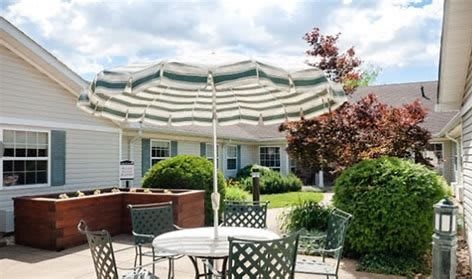 A cozy outdoor patio area with a table and chairs under a large striped umbrella.